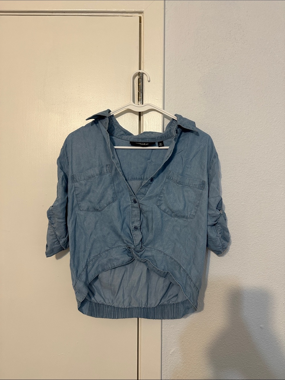 Gabrielle Union NY&CO button down blue top with pockets and button up sleeves.